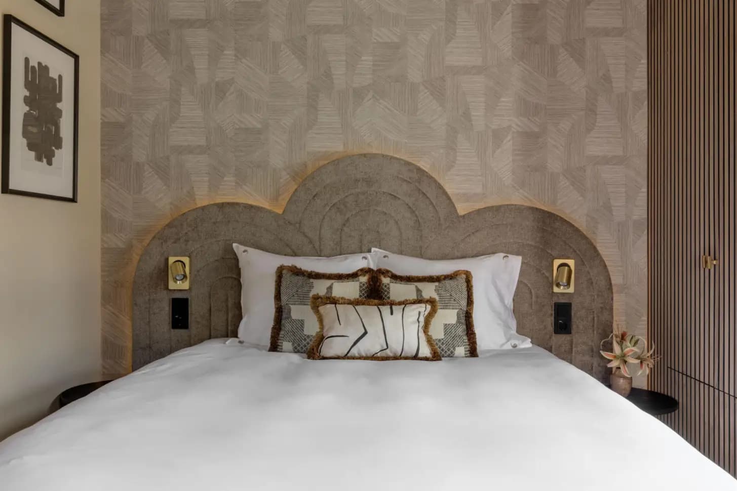 Bedroom with upholstered headboard and patterned wall
