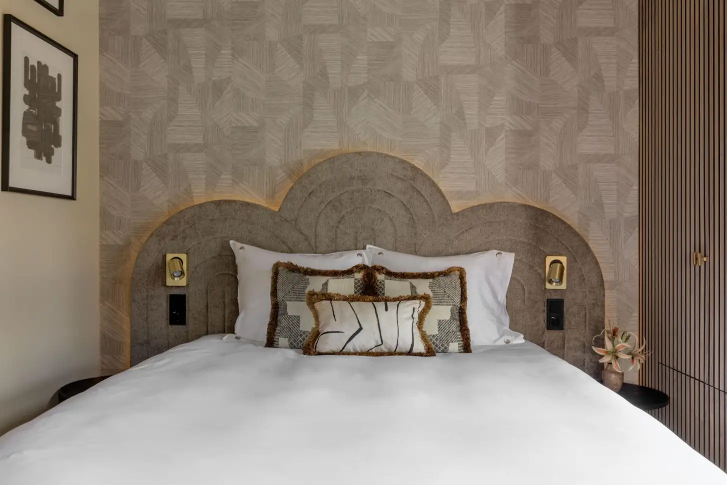 Bedroom with upholstered headboard and patterned wall